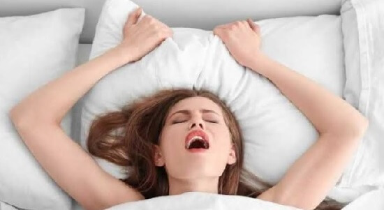 Девушка лежит в кровати и получает удовольствие от оргазма - картинка